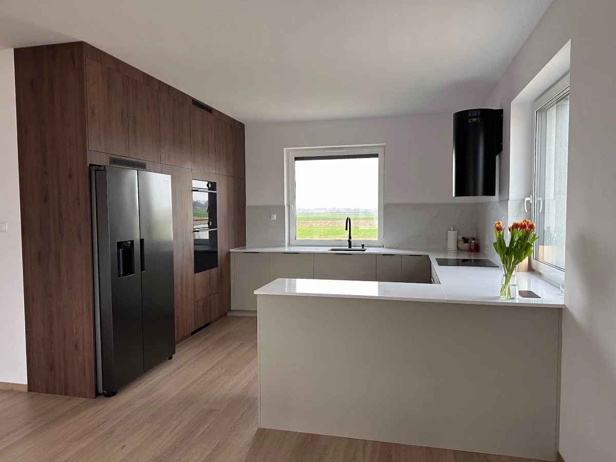 Biała kuchnia z zabudową w odcieniu ciemnego drewna